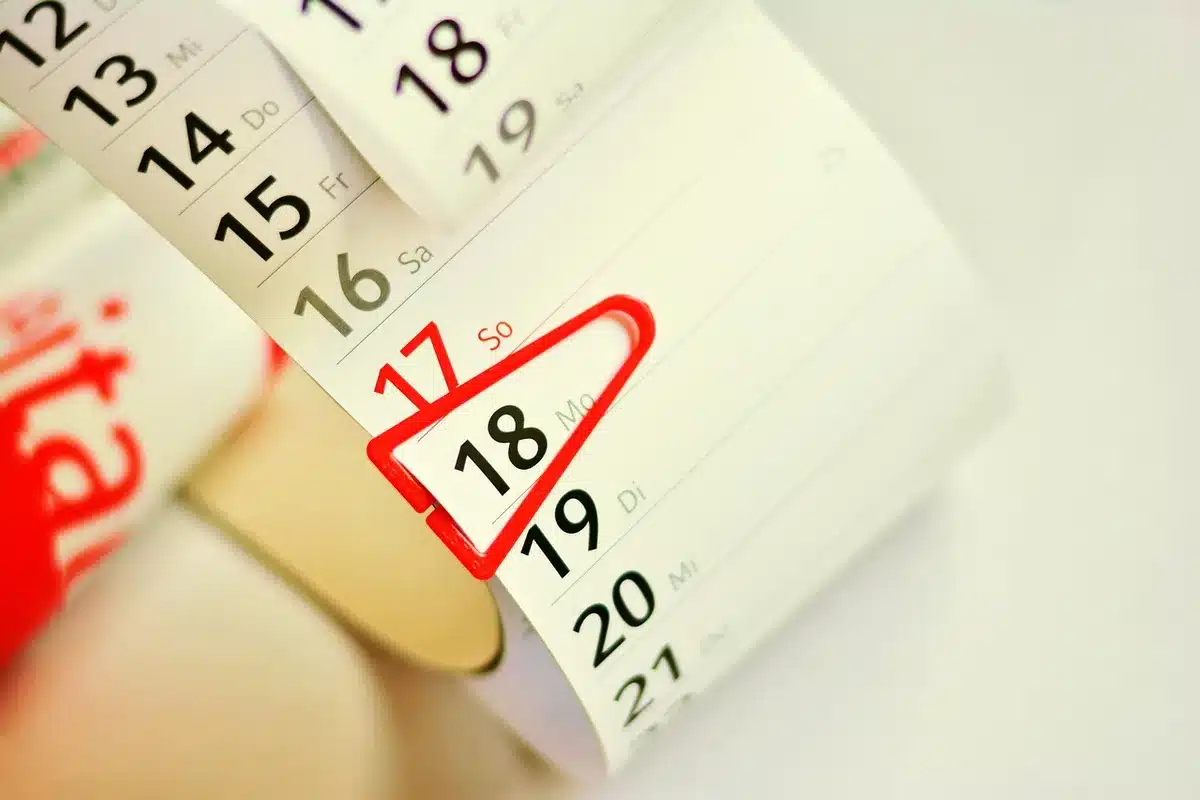 Documents administratifs et enveloppes sur une table avec un calendrier marquant le 1er avril