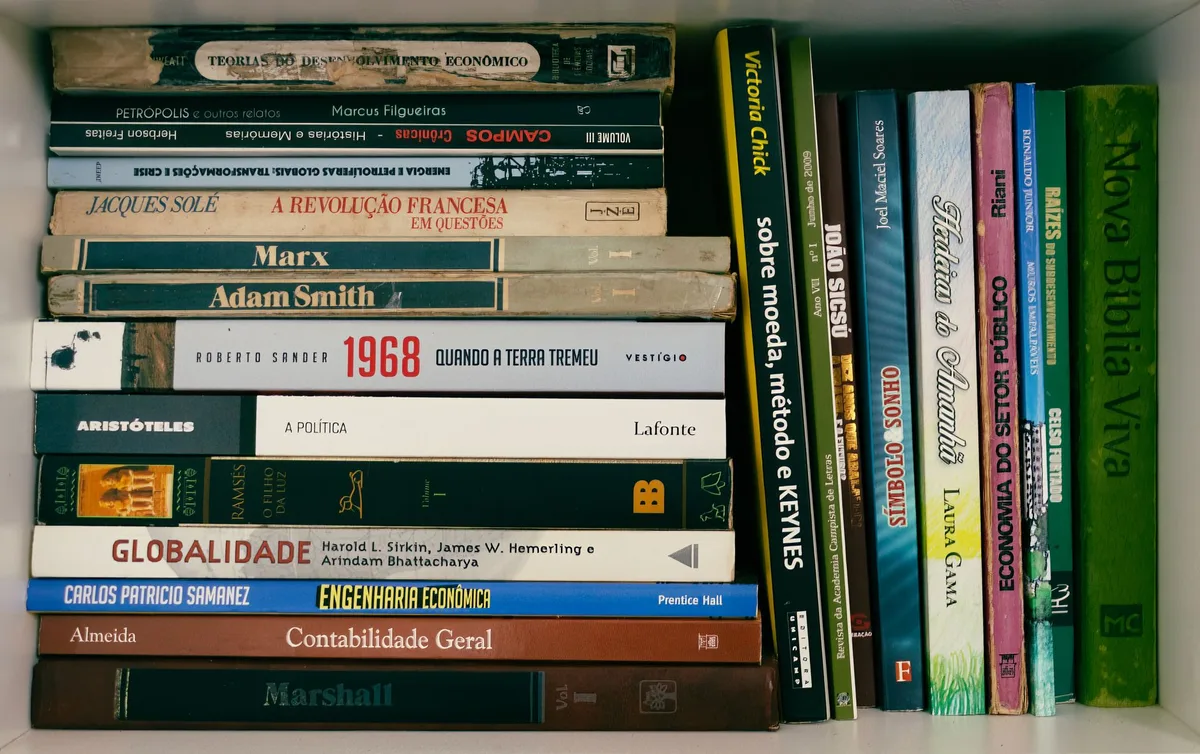 Plusieurs livres ouverts montrant des graphiques et des concepts économiques sur une table.
