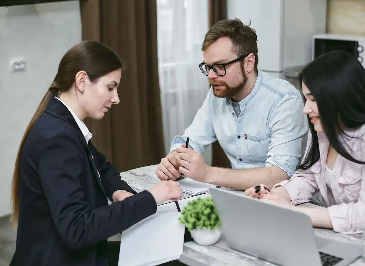 Investisseur examinant des documents financiers et un écran d'ordinateur portable à son bureau
