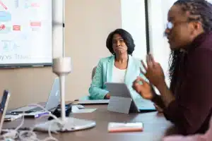 Manager écoutant attentivement un collaborateur lors d'une réunion d'équipe dans un bureau moderne
