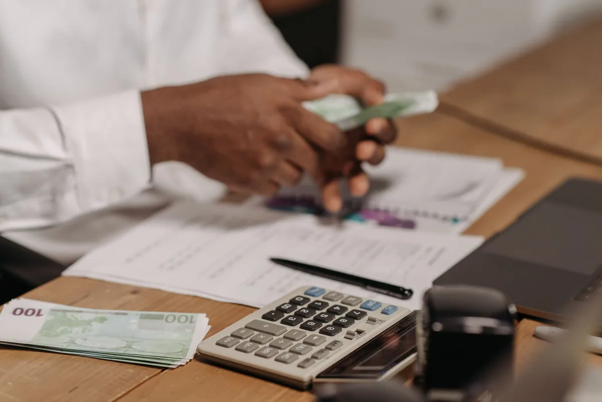 Bureau de freelance avec calculatrice, factures et documents financiers pour calculer les revenus nets