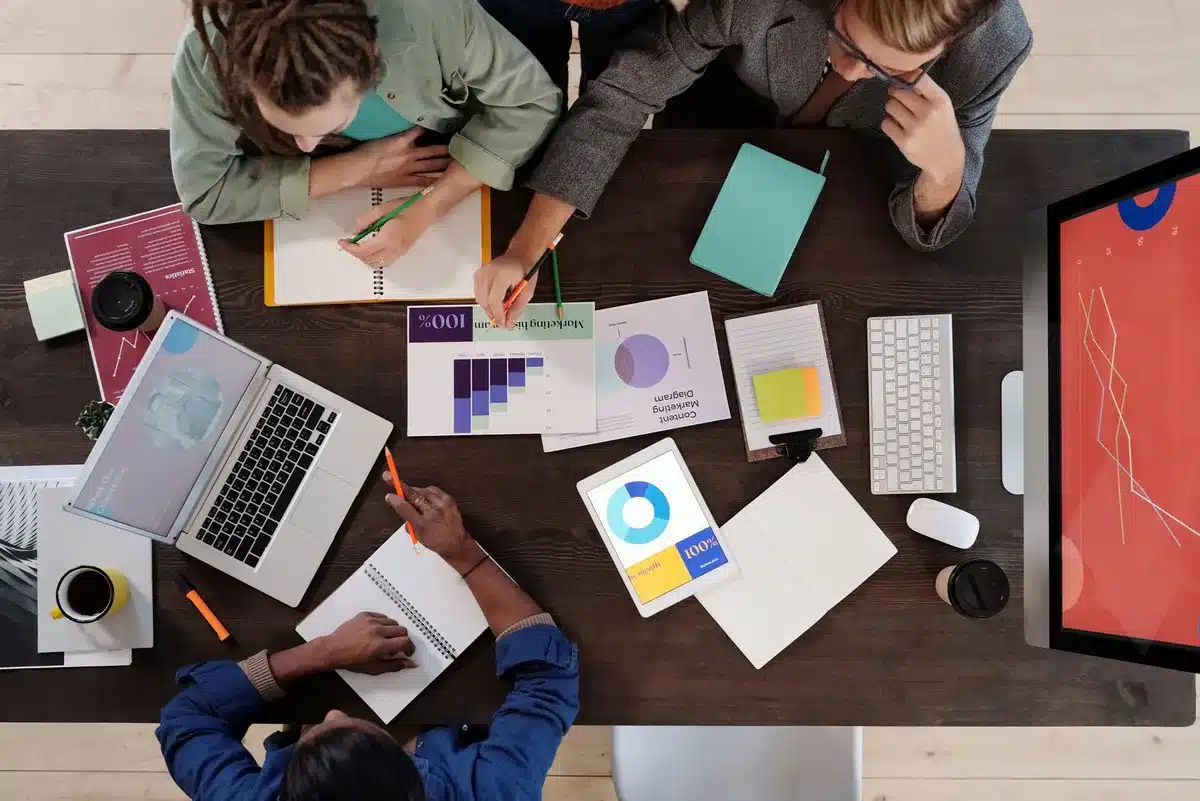 Équipe collaborant autour d'un écran affichant des outils numériques de brainstorming