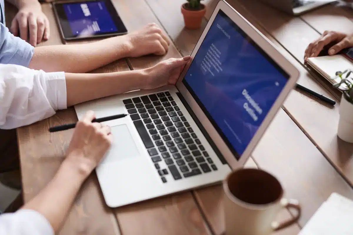 Espace de travail avec un ordinateur portable affichant une carte mentale colorée avec branches et nœuds interconnectés