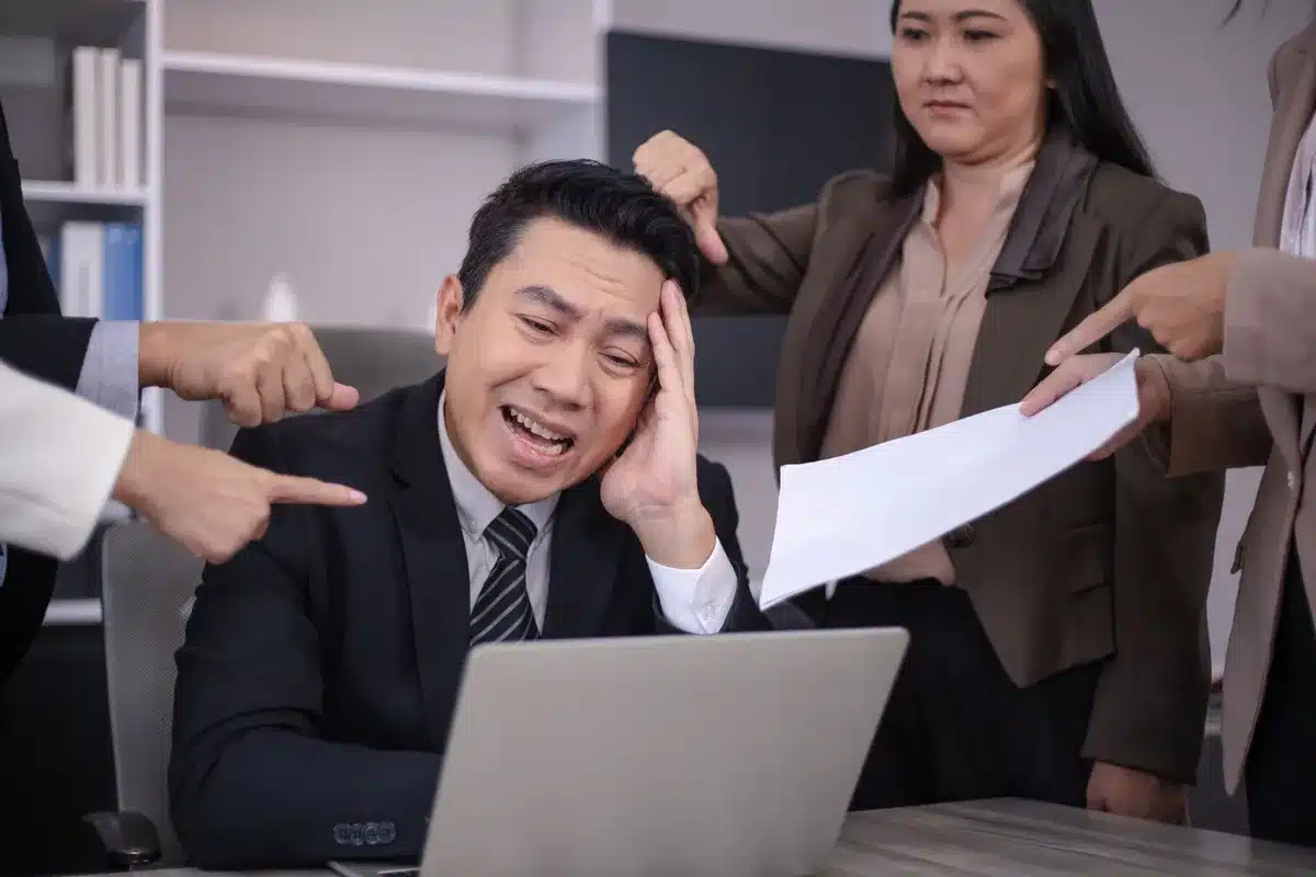 Personne stressée au bureau face à des défis professionnels et relationnels.