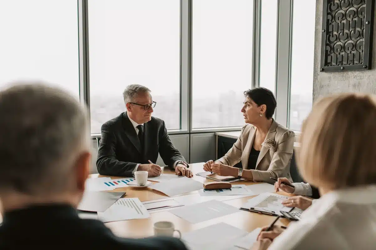 Deux professionnels en conversation constructive dans un cadre neutre et professionnel.