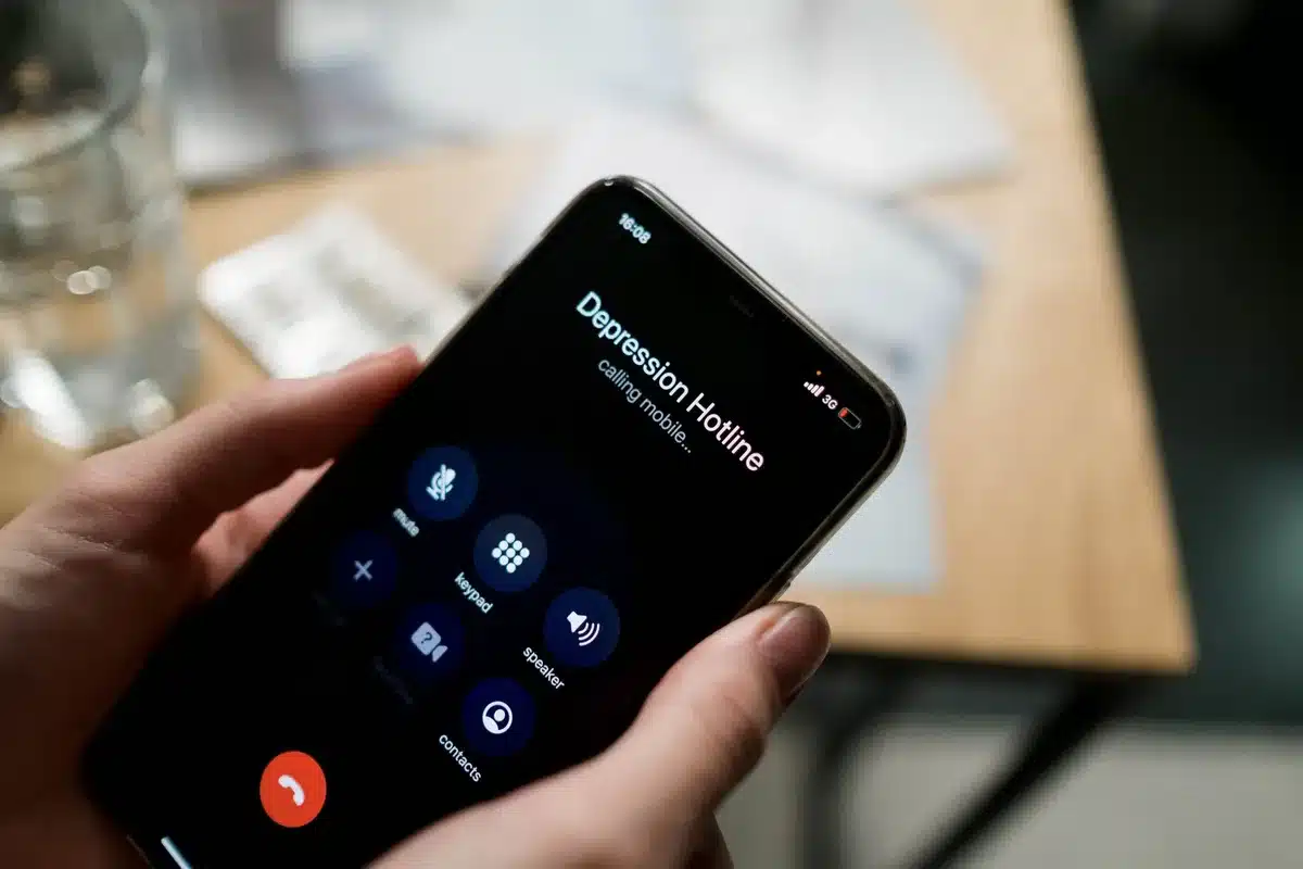 Une personne contactant les services sociaux par téléphone pour obtenir de l'aide au logement
