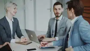 Réunion d'équipe autour d'une table avec participants concentrés et documents partagés