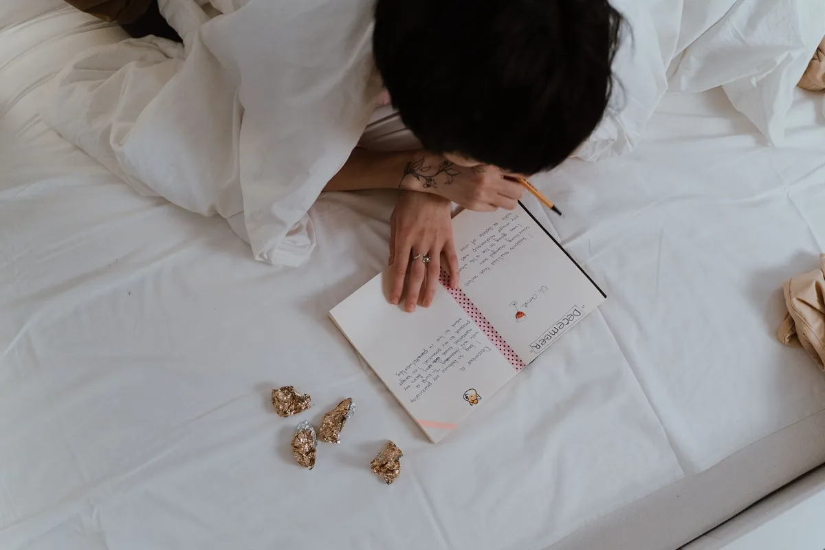 Personne écrivant une citation dans un carnet le matin, moment de routine personnelle.