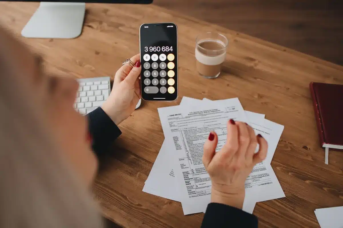 Feuilles d'impôts, calculatrice et stylo sur un bureau