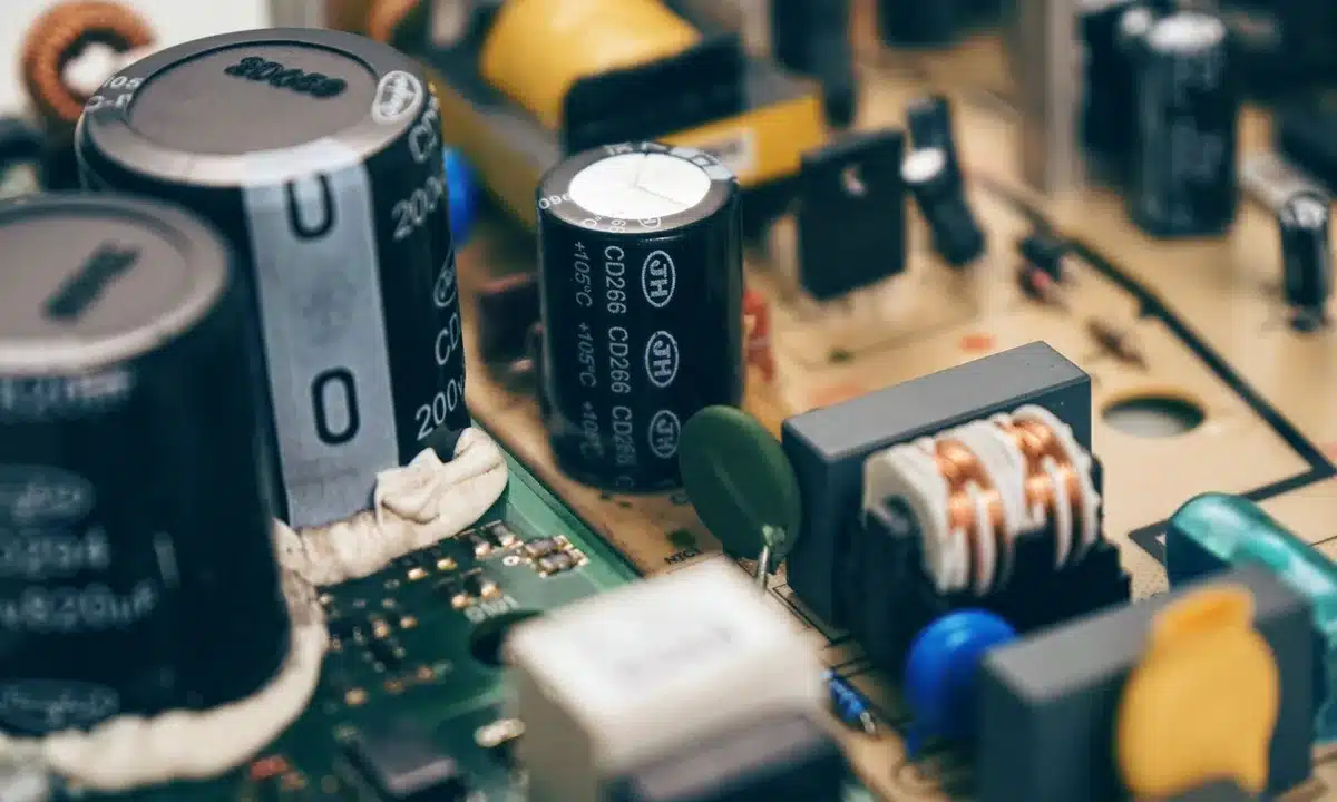 Des mains tenant une jeune pousse au-dessus d'un circuit imprimé, symbolisant la croissance technologique et l'investiss