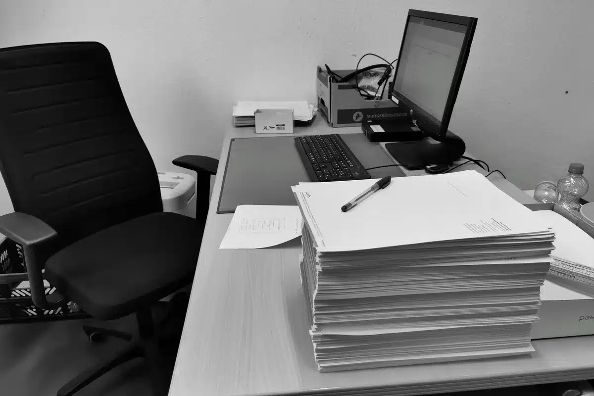 Dossier de permis de construire avec documents administratifs sur un bureau.