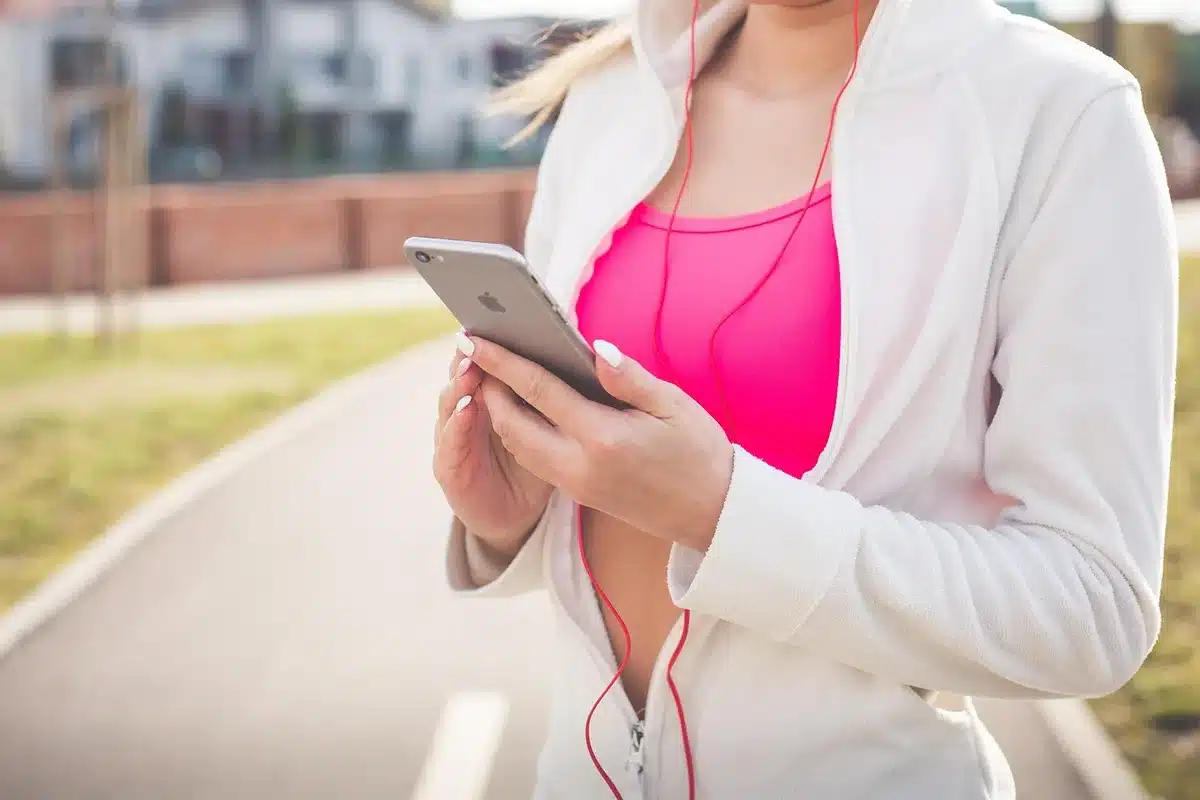 Femme marchant en consultant une application mobile de suivi d'activité physique