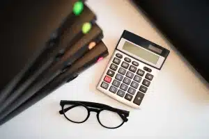Documents fiscaux, amortissement et calculatrice sur un bureau pour calcul de plus-value LMNP