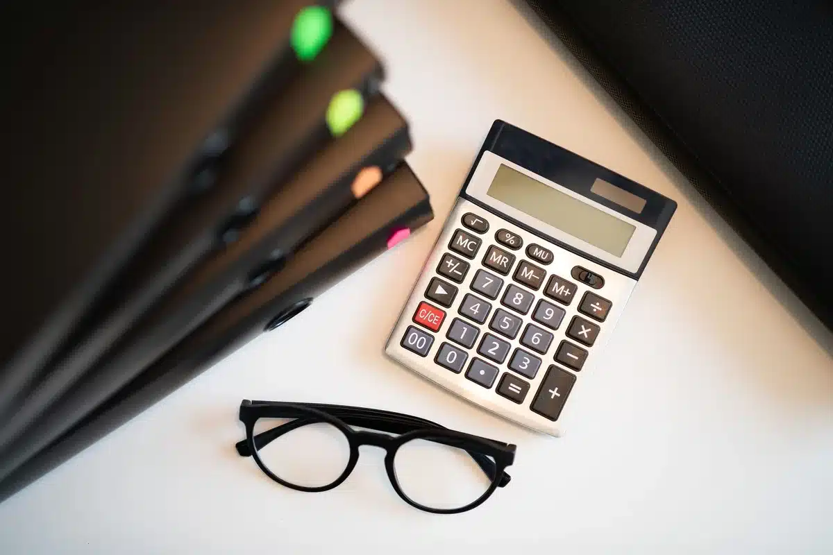 Documents fiscaux, amortissement et calculatrice sur un bureau pour calcul de plus-value LMNP