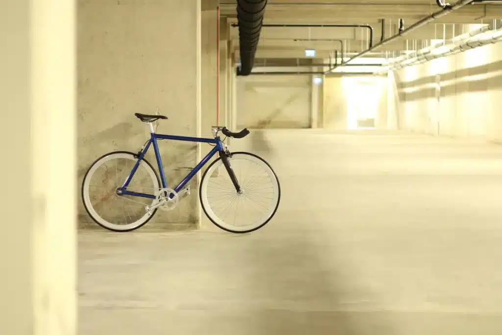 Local sécurisé pour vélos en immeuble avec rangements fixes et espace d'accès