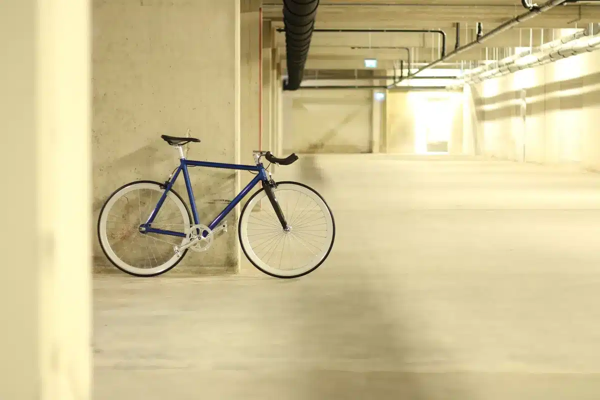 Local sécurisé pour vélos en immeuble avec rangements fixes et espace d'accès