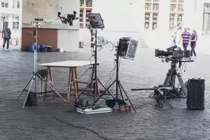 Équipe de tournage installant l'éclairage et les câbles dans un salon résidentiel