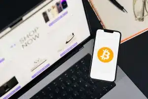 Main tenant un portefeuille numérique sur un écran de smartphone avec des icônes bancaires en arrière-plan
