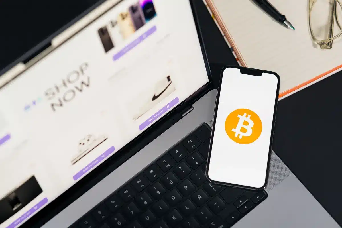 Main tenant un portefeuille numérique sur un écran de smartphone avec des icônes bancaires en arrière-plan