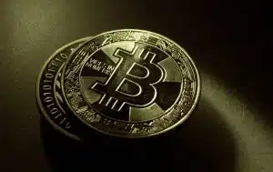 Symbole d'alerte rouge superposé sur des pièces de cryptomonnaie et des motifs numériques flous