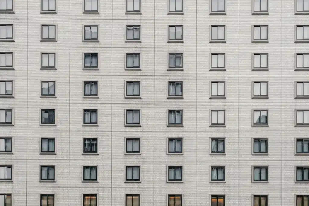 Façade d'immeuble résidentiel avec fenêtres vides symbolisant les logements vacants