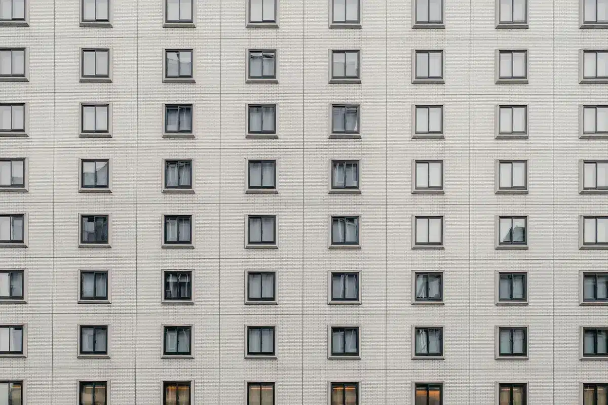 Façade d'immeuble résidentiel avec fenêtres vides symbolisant les logements vacants