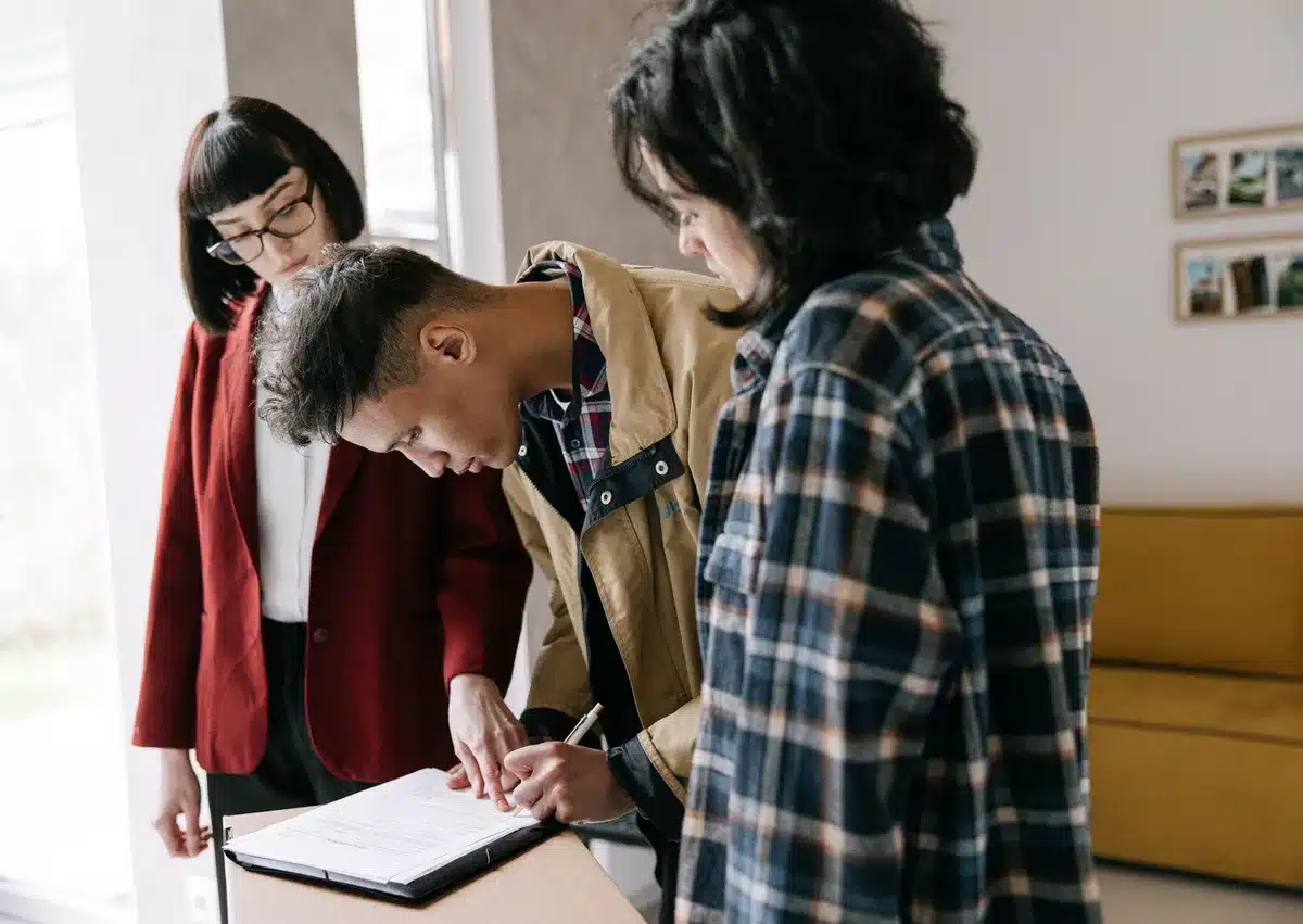 Signature de documents de crédit immobilier à un bureau avec stylo et calculatrice