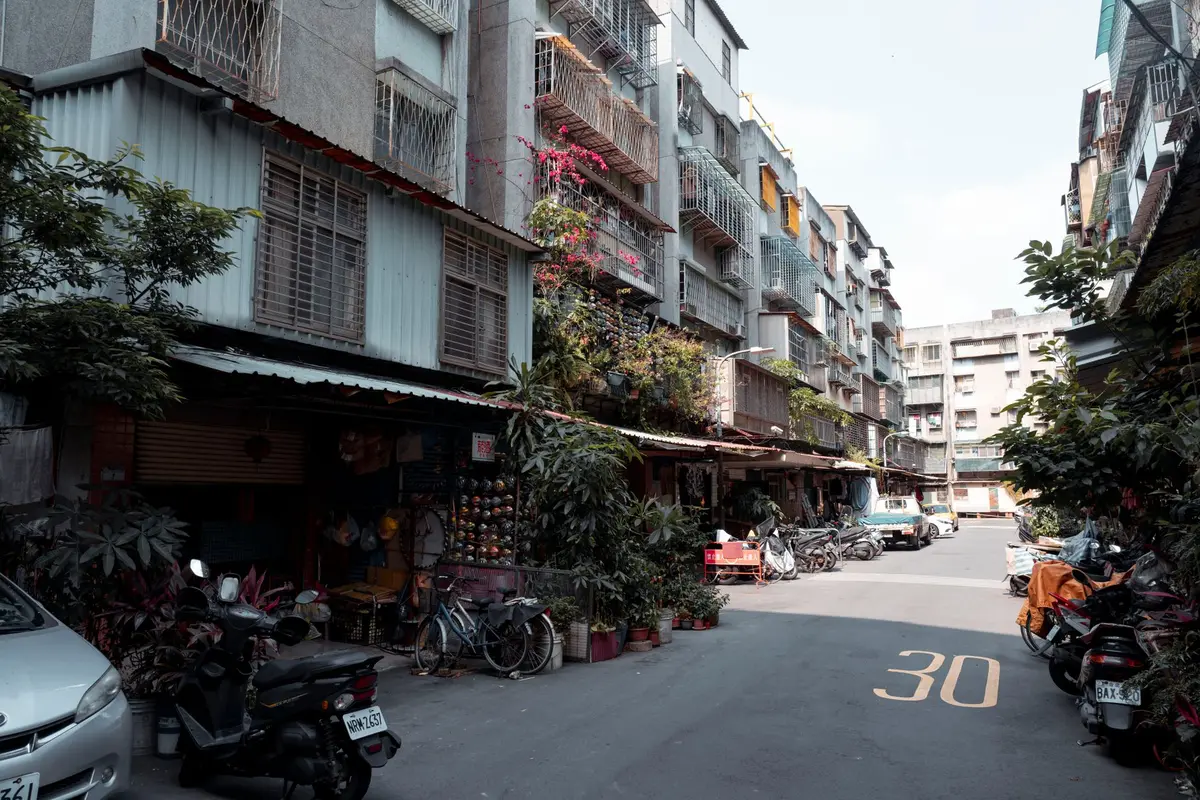Vue d'une rue résidentielle avec immeubles et commerces, illustrant le choix stratégique du quartier