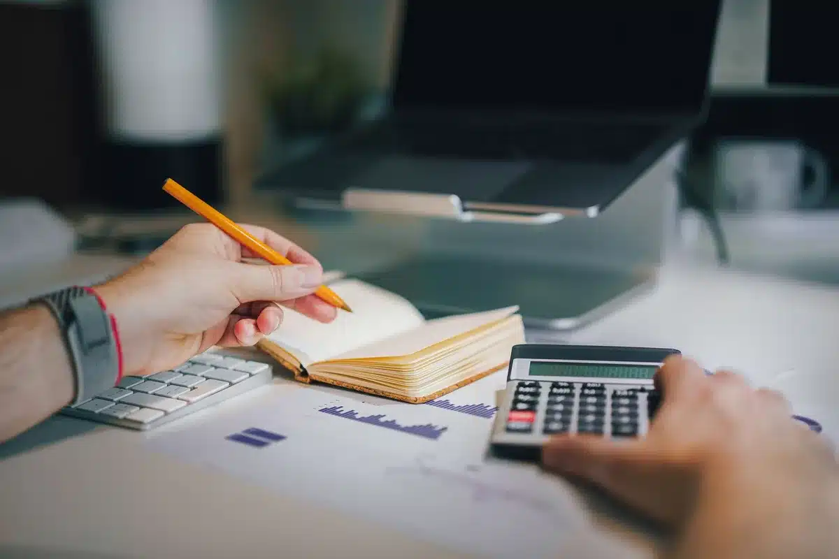 Documents d'investissement immobilier et calculatrice sur un bureau d'analyste financier