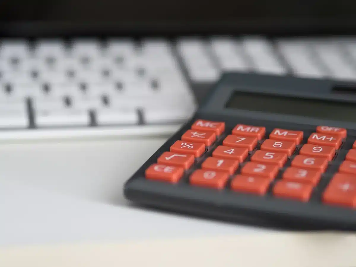 Carnet d'épargne et calculatrice sur un bureau en lumière du jour