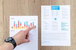 Document d'assurance‑vie, calculatrice et graphique sur un bureau éclairé par la lumière du jour