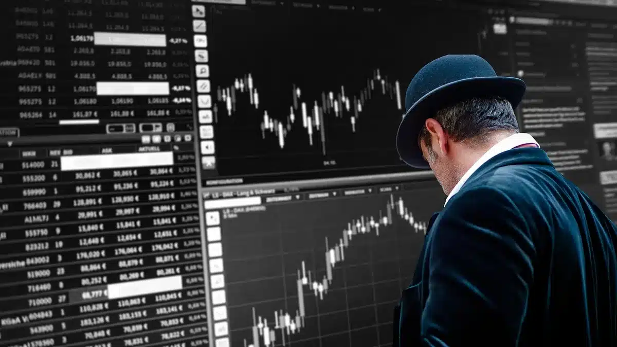 Écrans boursiers et traders flous montrant l'incertitude des marchés