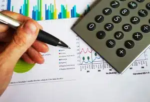 Carnet de budget et calculatrice sur table avec reçus, illustrant l'éducation financière