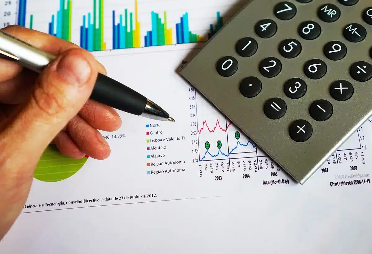 Carnet de budget et calculatrice sur table avec reçus, illustrant l'éducation financière