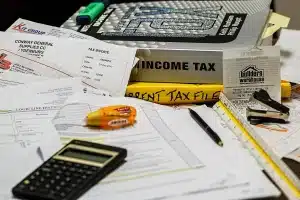 Bureau en plein jour avec documents financiers et calculatrice près d'une fenêtre