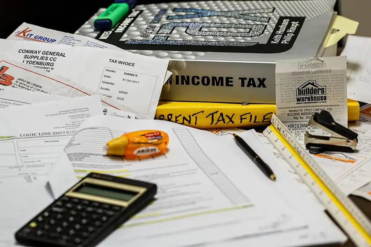 Bureau en plein jour avec documents financiers et calculatrice près d'une fenêtre