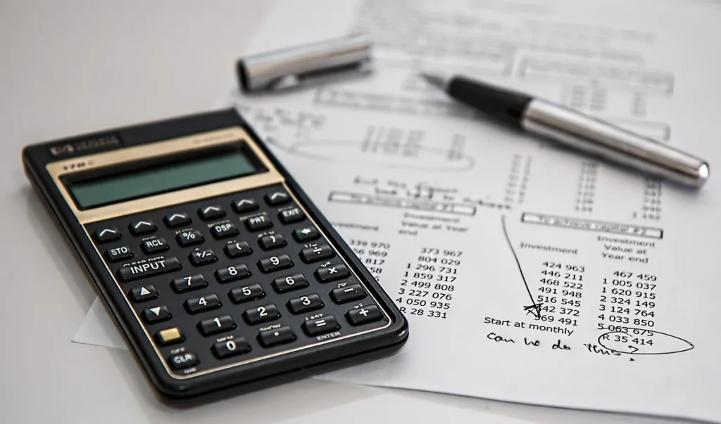 Bureau avec formulaires fiscaux, documents budgétaires et calculatrice en désordre