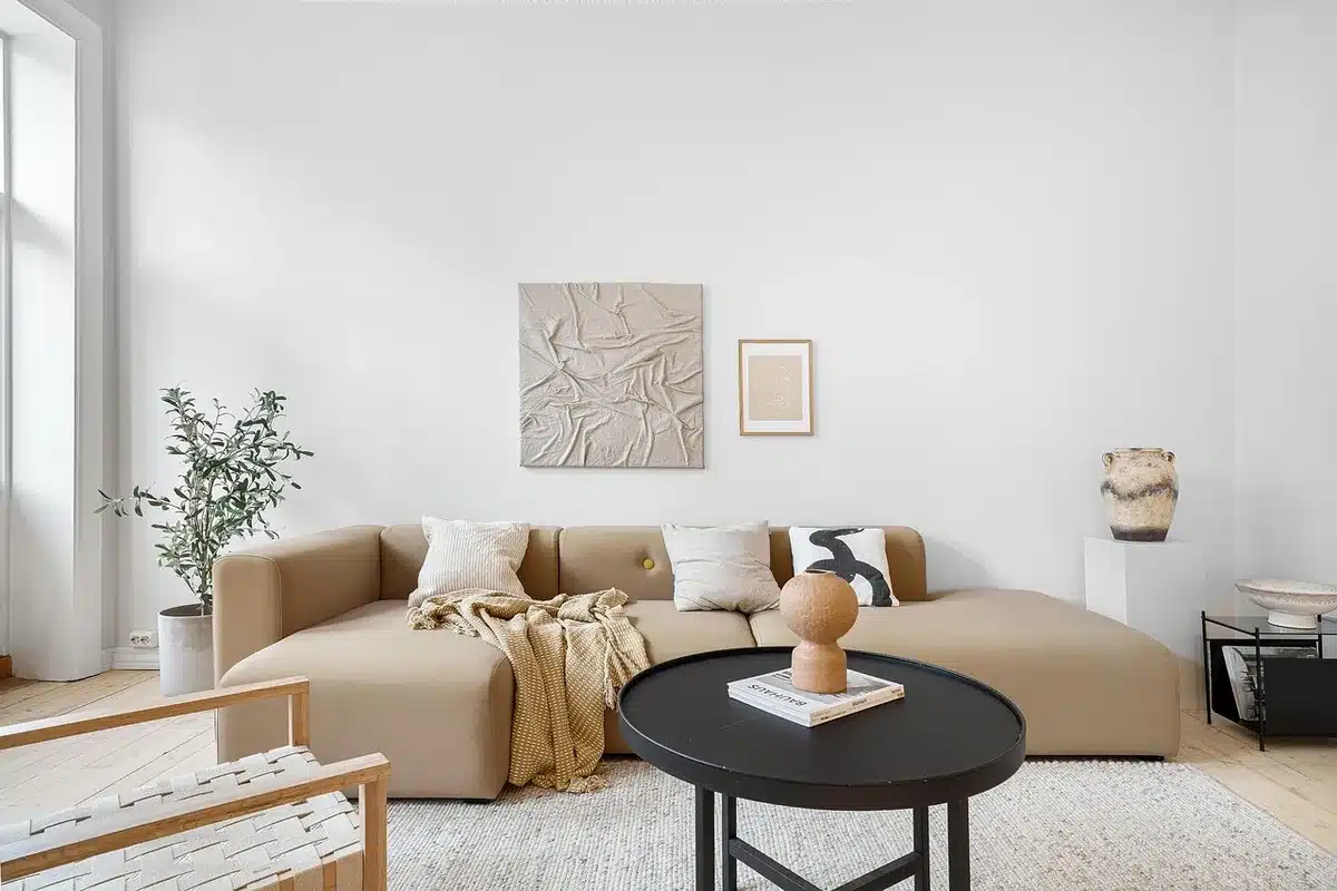 Appartement en plein jour avec fenêtre, volets partiellement fermés et ventilateur sur une table