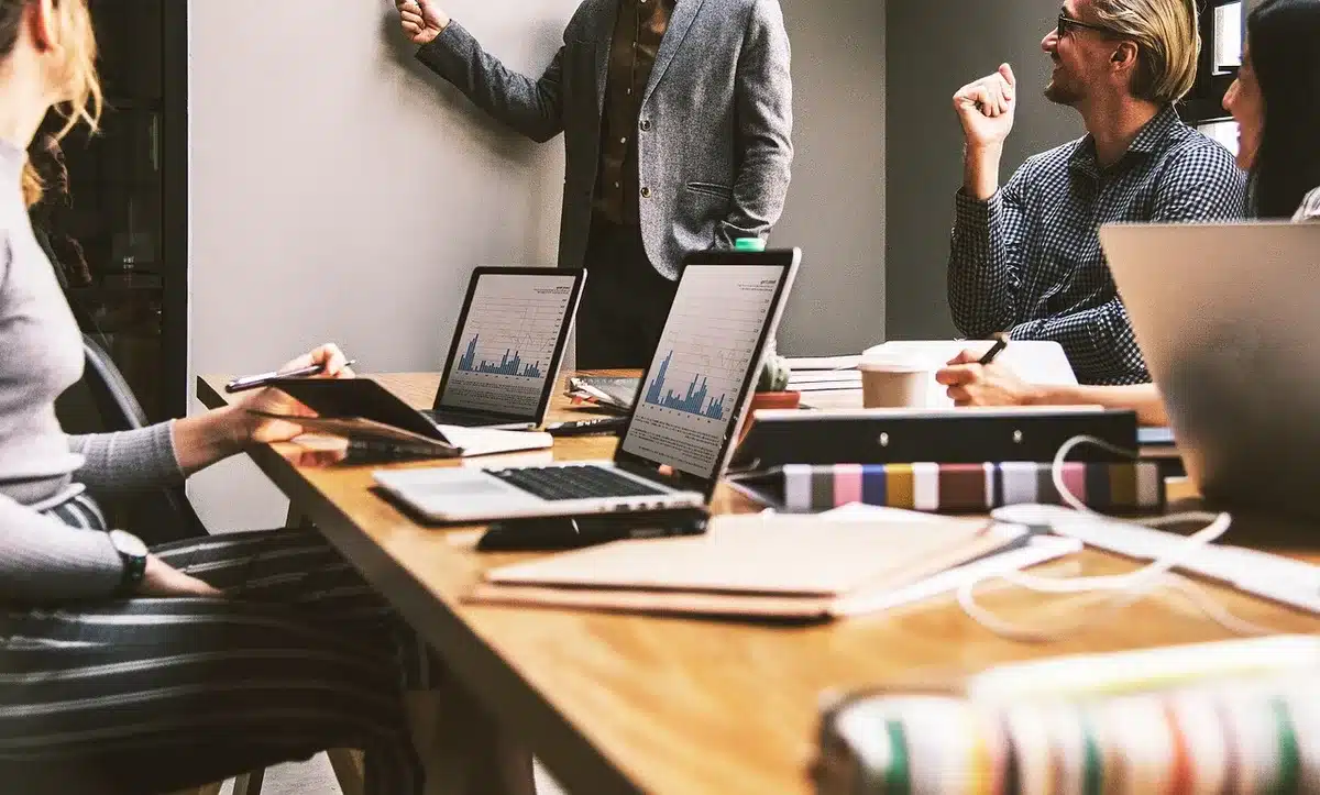 Employeur et salarié discutant d'un plan de formation près d'une fenêtre en journée