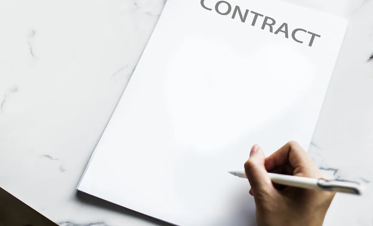 Contrat et mentions légales sur un bureau pour une collaboration sponsorisée