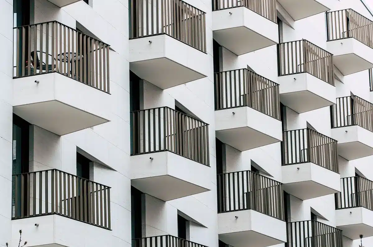 Arbres et brise-soleil sur balcon créant de l'ombre naturelle