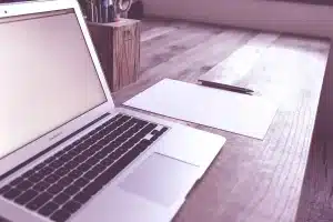 Bureau en journée avec carnet de tâches, stylo et tasse de café près d'une fenêtre