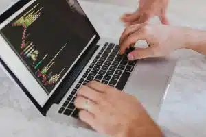 Espace de travail technologique avec écrans affichant du code et des données