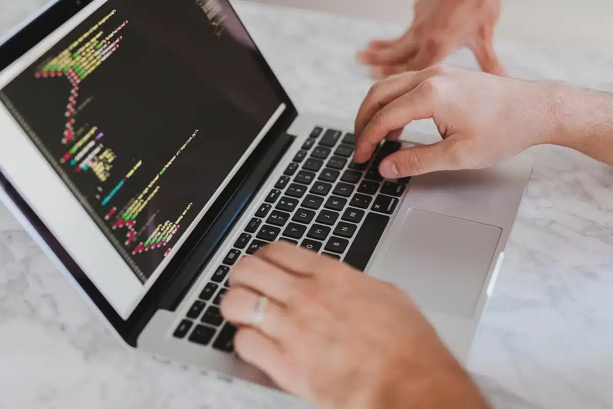 Espace de travail technologique avec écrans affichant du code et des données
