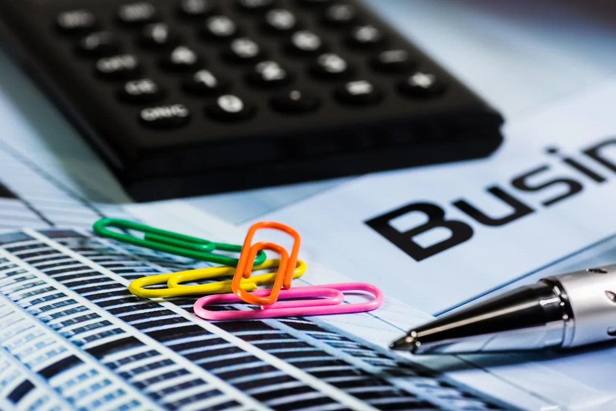 Relevés et calculatrice posés sur une table pour analyser les frais