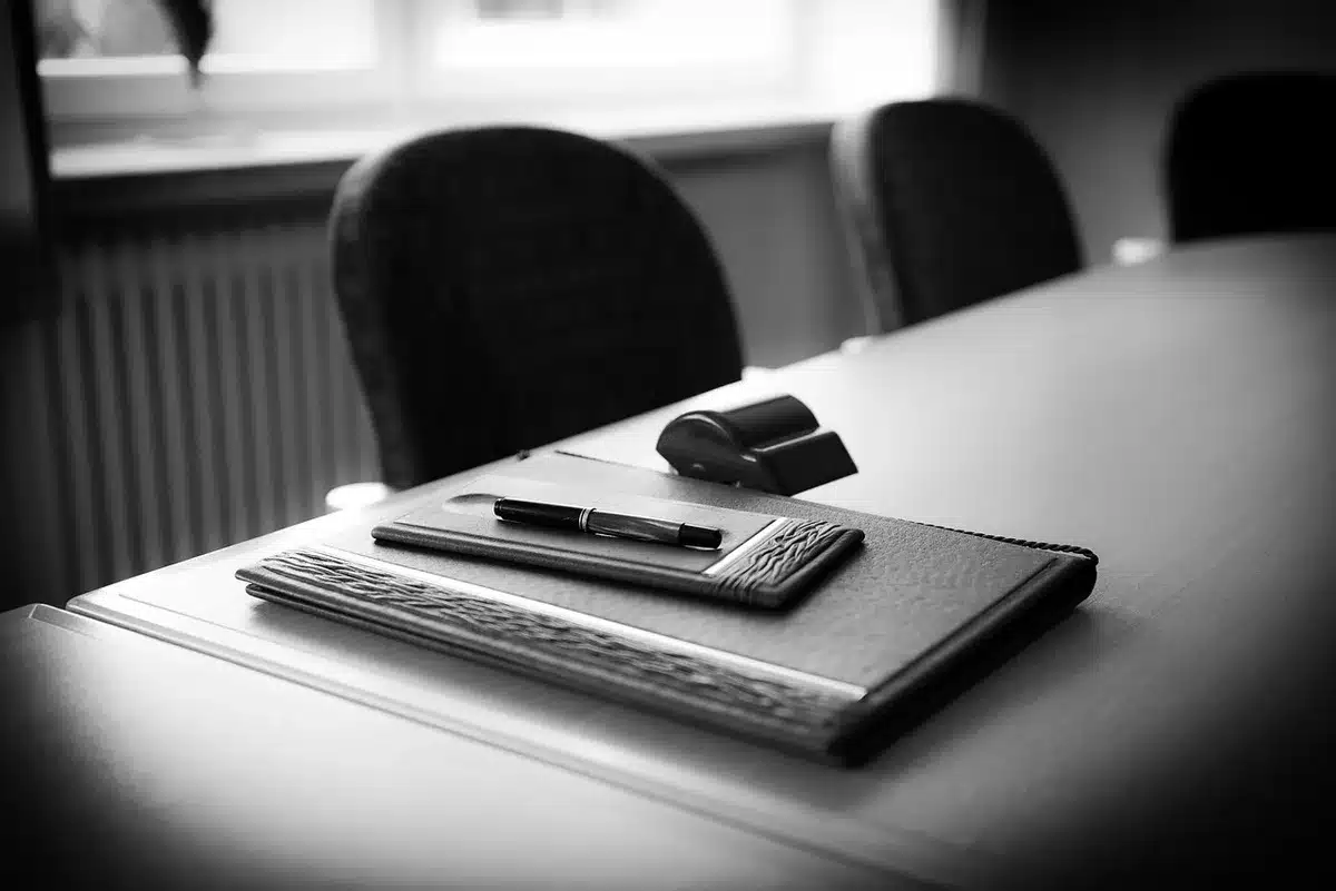 Main tenant des documents et un prospectus d'investissement sur un bureau