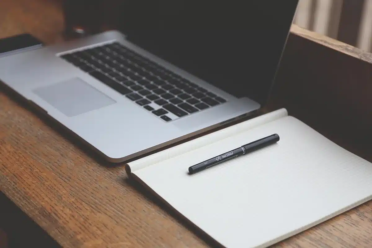 Bureau à domicile en plein jour, mains tenant une fiche de fonds et un stylo