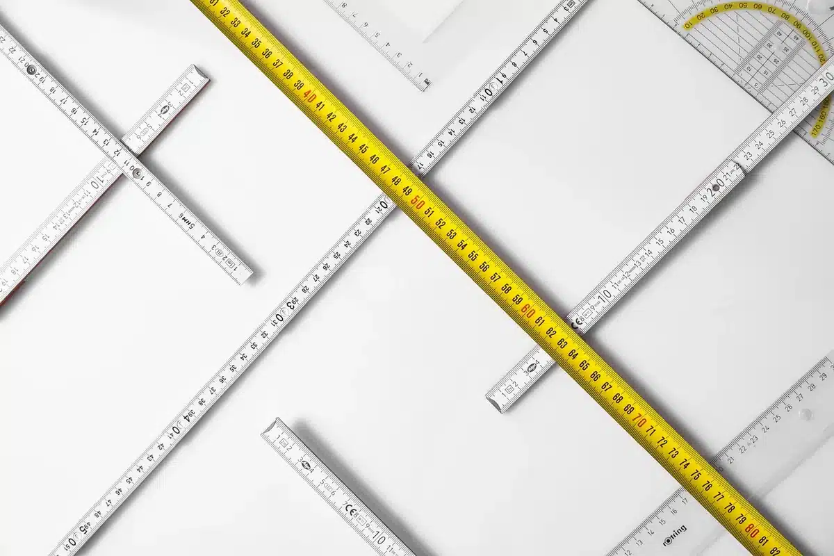 Mètre ruban posé sur un plan et une règle indiquant la surface