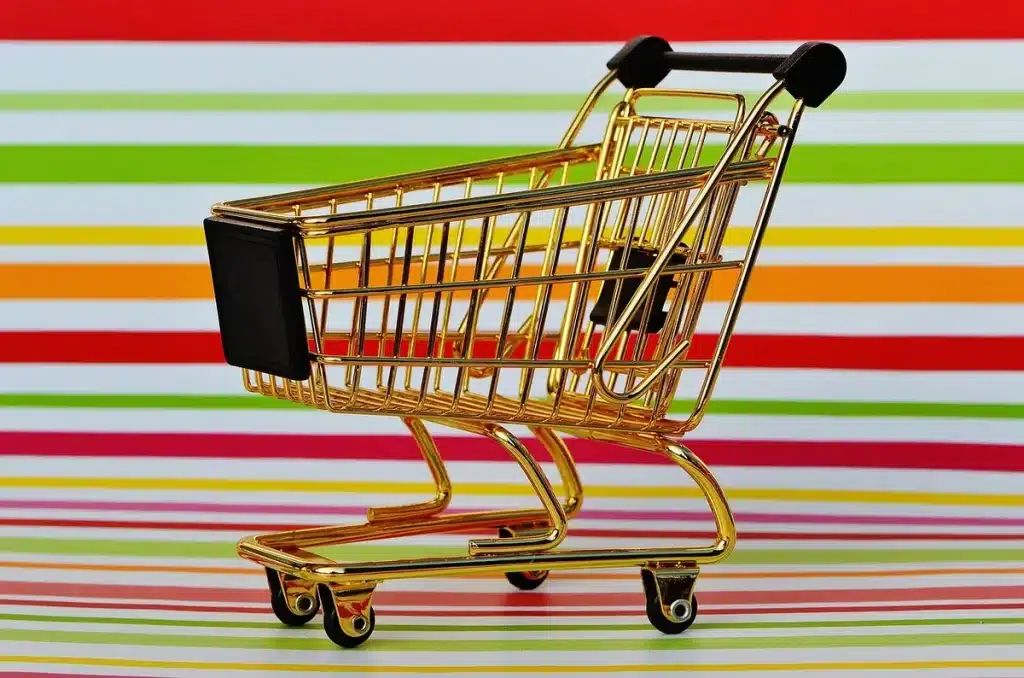 Caddie et rayons partiellement vides dans un supermarché illustrant la modération des prix