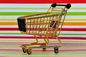 Caddie et rayons partiellement vides dans un supermarché illustrant la modération des prix